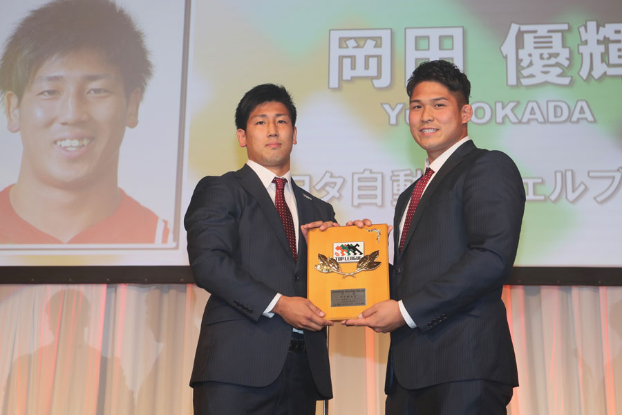 昨季の受賞者かつチームの主将でもあるFL姫野から盾を受け取る新人賞の岡田(トヨタ自動車WTB)photo by Kenji Demura