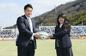 贈呈式でキャプテン会議代表の竹本選手から公式球を受け取る和歌山県立熊野高校ラグビー部 女子部員、濱未優さん